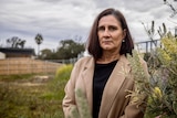 A woman standing in a vacant lot