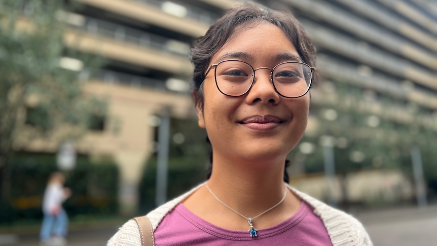 a young woman wearing glasses smiling