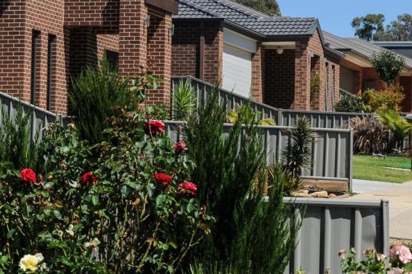 A series of similar-looking brick homes with steel fences