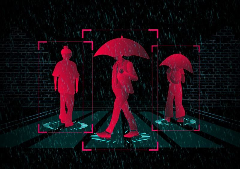 An illustration shows a pedestrian crossing with three people walking across it. Two are holding umbrellas.
