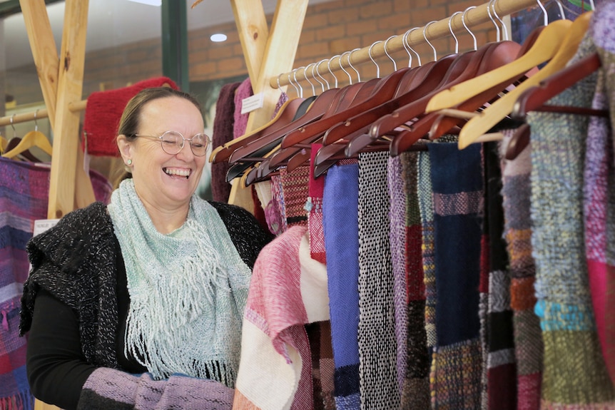 Angela in her Yarragon shop, next to a row of colourful clothes