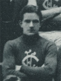 A black and white photo of a footballer with his arms crossed.