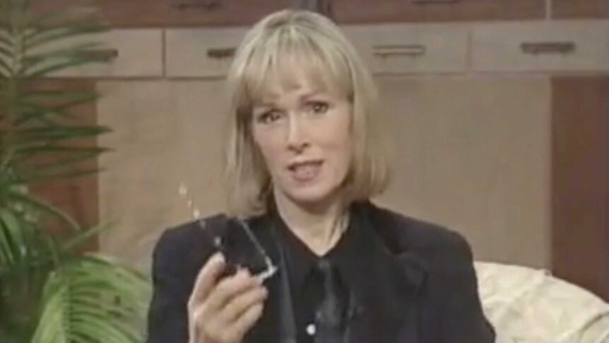 E. Jean Carroll wears a black shirt, black tie and black jacket