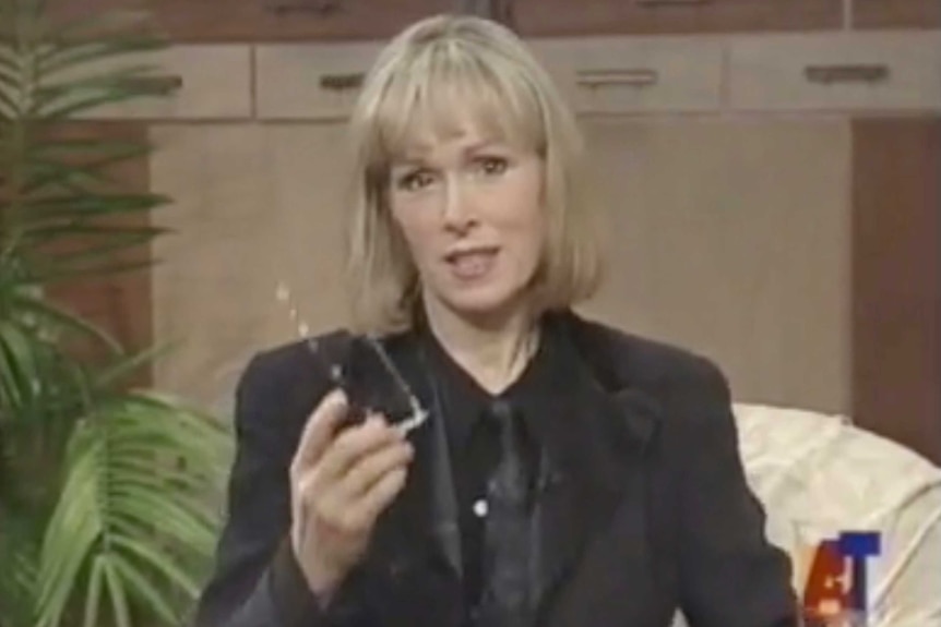 E. Jean Carroll wears a black shirt, black tie and black jacket