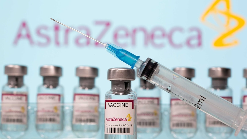 A needle balanced on a vial of the AstraZeneca vaccine