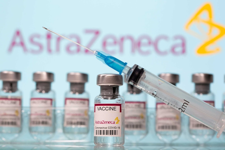 A needle balanced on a vial of the AstraZeneca vaccine