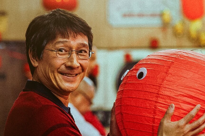 a still of Ke Huy Quan in Everything Everywhere All At Once, holding a red lantern