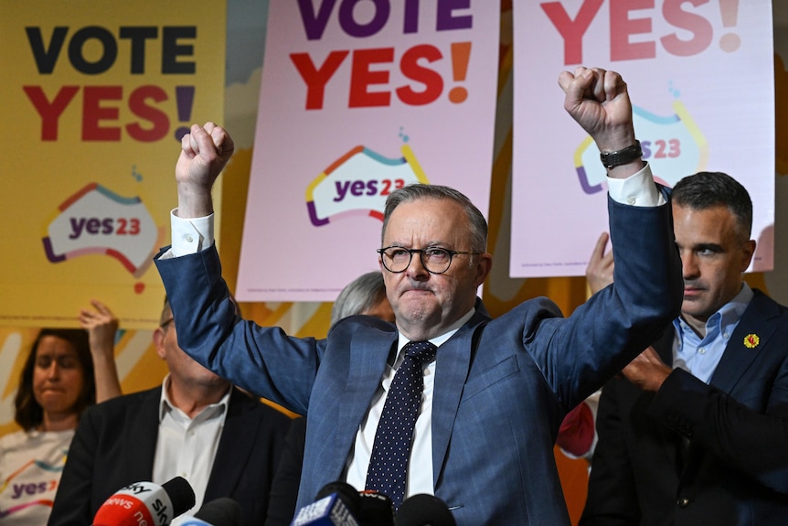 ANTHONY ALBANESE  with his hands in the air surrounded by Yes signs. 