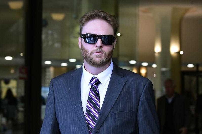A man wearing a suit and dark sunglasses.