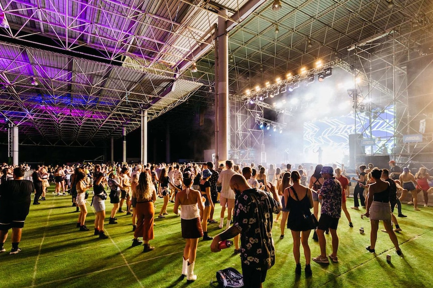 Revellers dancing in designated squares painted on the grass.