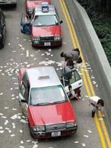 Taxi drivers stop to pick up cash in Hong Kong