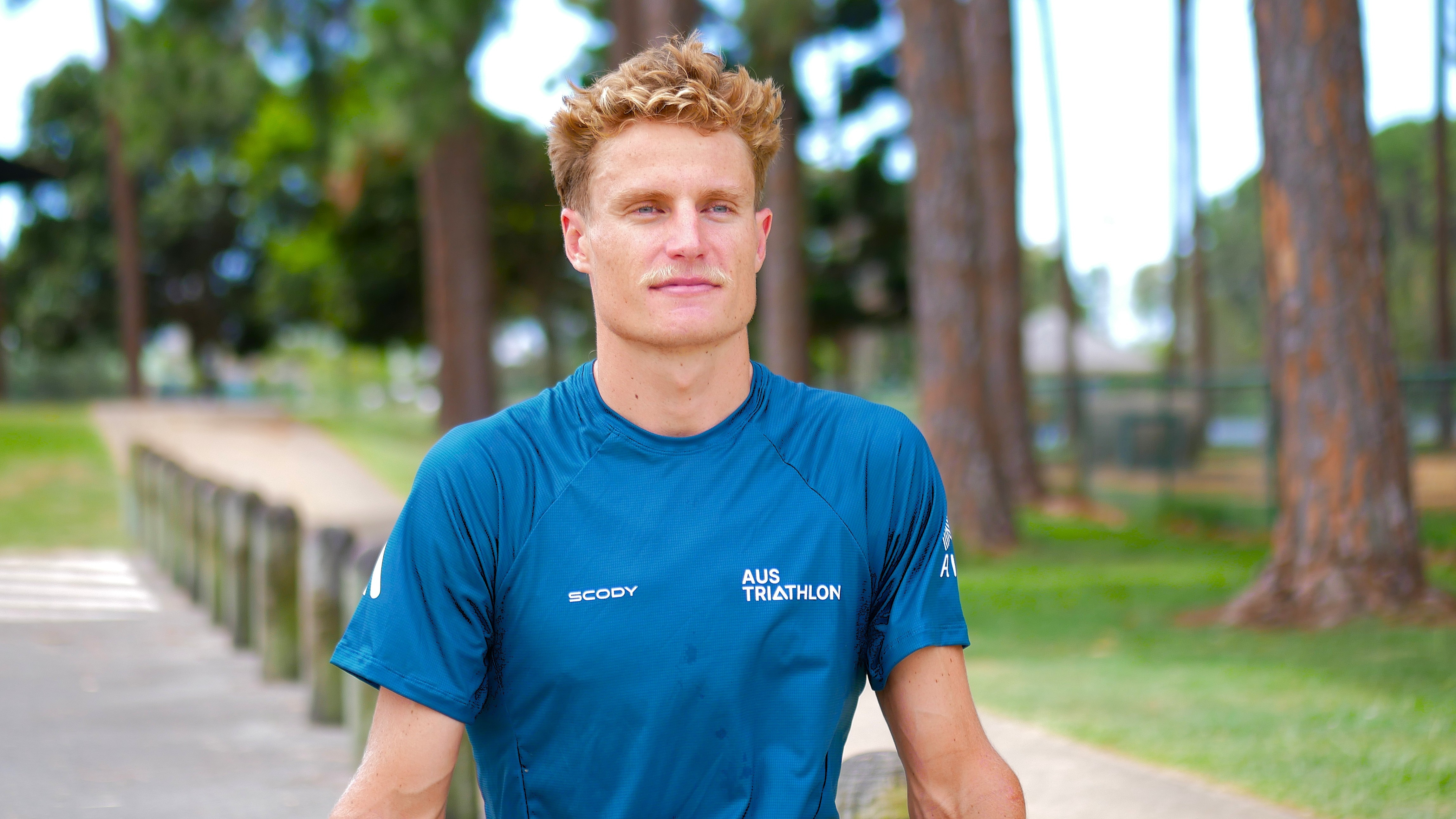 Matthew Hauser olha para longe enquanto está perto de uma pista de corrida na Gold Coast.