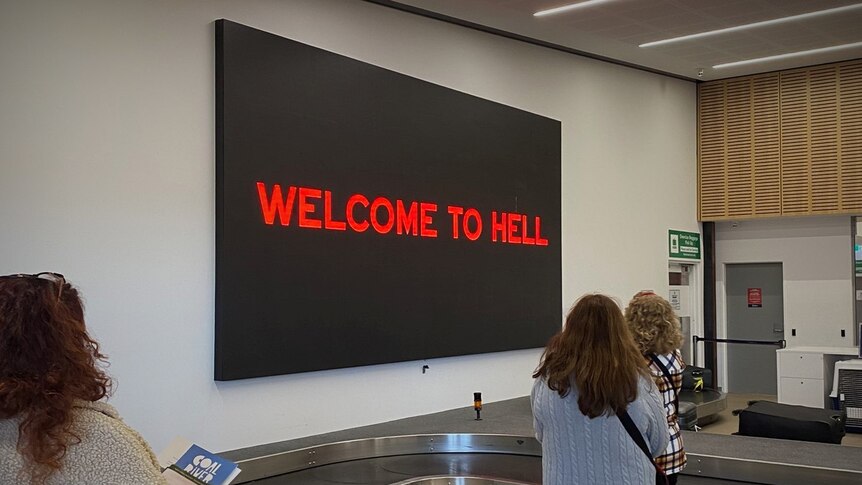 Welcome to Hell sign at Hobart airport baggage claim.