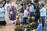 People attend a funeral service for victims of the earthquake, at a gymnasium arranged in a chapel of rest on August 27, 2016