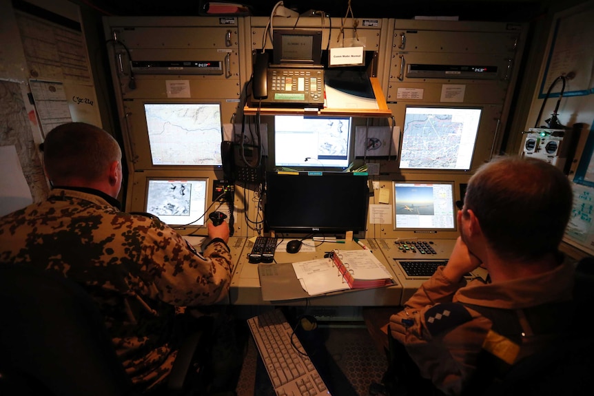 A German Bundeswehr armed forces pilot operator and an aerial vehicle operator control a UAV.