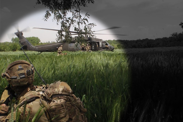 spotlight on a special forces soldier and helicopter in an Afghanistan field.