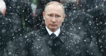 Vladimir Putin standing in the snow.