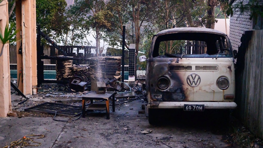Burnt kombi van and yard at a house after a bushfire at Peregian Beach
