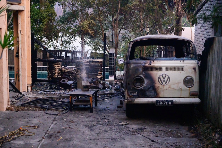 Burnt kombi van and yard at a house after a bushfire at Peregian Beach