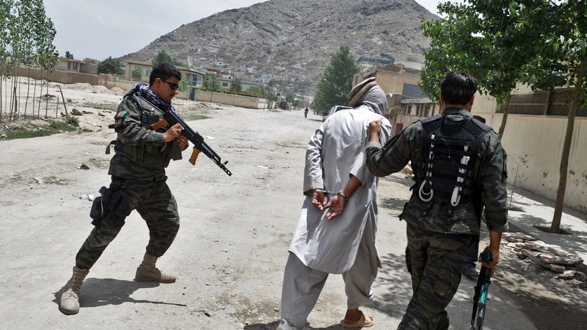 Under attack: security forces arrest a man during a clash with insurgents near the peace jirga tent in Kabul