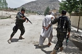 Under attack: security forces arrest a man during a clash with insurgents near the peace jirga tent in Kabul