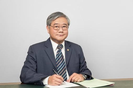 Hong Lim sits at a desk.