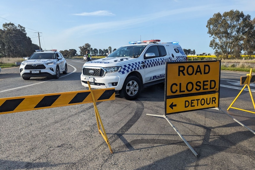 Police cars behind a road closed sign on the Goulburn Valley Highway.