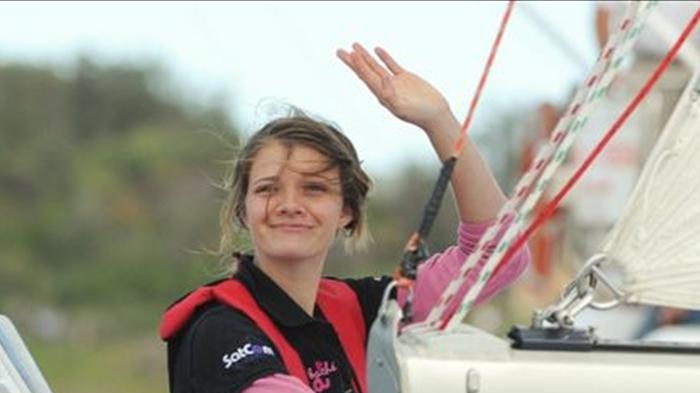 Jessica Watson waves and smiles as she sails into Sydney Harbour after her 210-day journey.