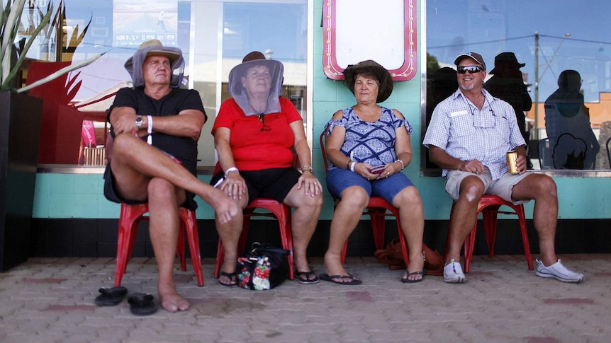 Two men and two woman sit in front of the iconic North Gregory Hotel in Winton in western Queensland in April 2018.