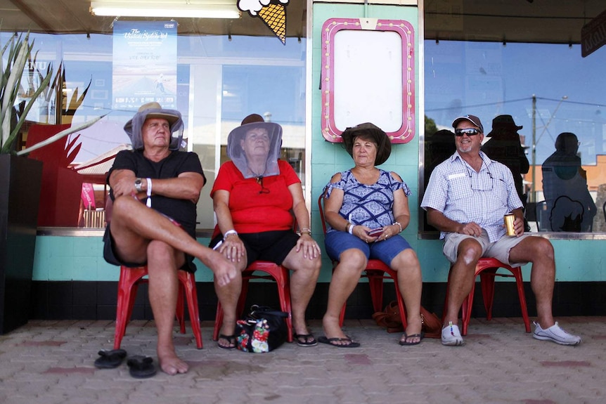 Two men and two woman sit in front of the iconic North Gregory Hotel in Winton in western Queensland in April 2018.