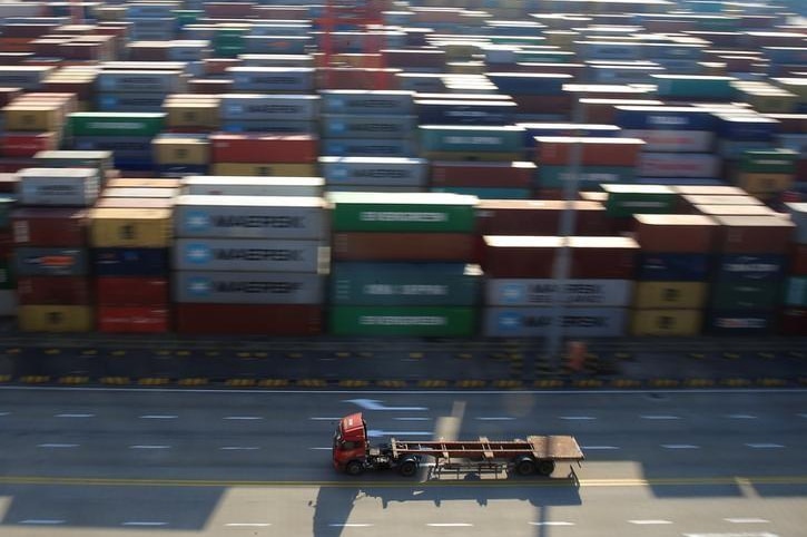 A truck drives past container boxes at the Yangshan Deep Water Port, part of the Shanghai Free Trade Zone, in Shanghai, China.