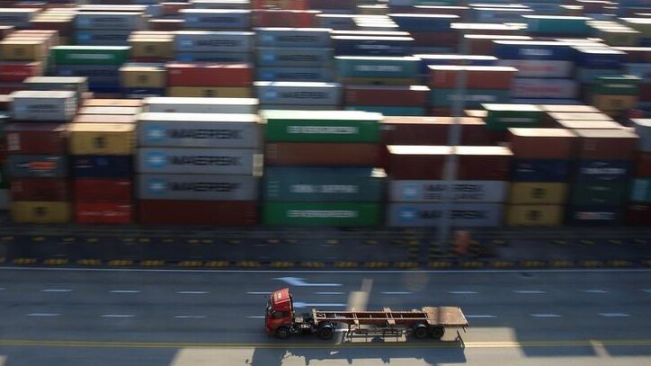 A truck drives past container boxes at the Yangshan Deep Water Port, part of the Shanghai Free Trade Zone, in Shanghai, China.