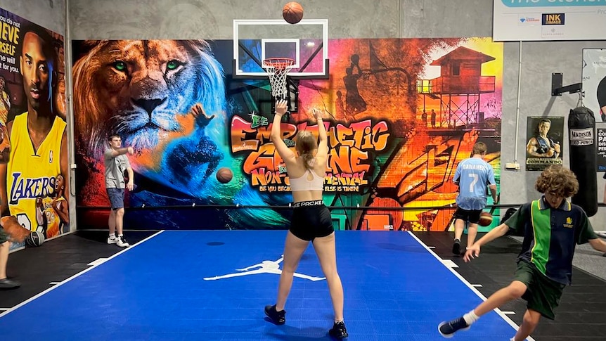 A bright basketball court with kids playing