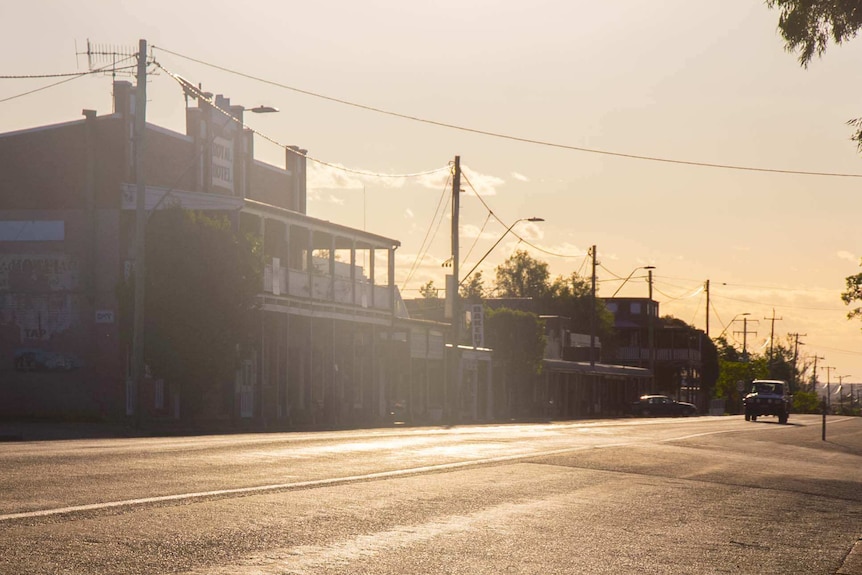 Historic town streetscape architecture with car driving down road.