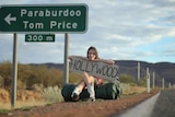 Kara Lauder on the side of the road with a Hollywood sign.