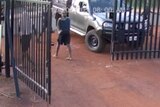 Young people surround a ute and smash windows