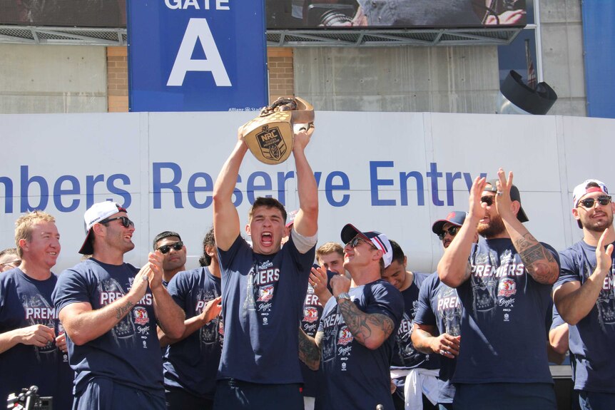 Victor Radley holds the trophy high as the Roosters celebrate