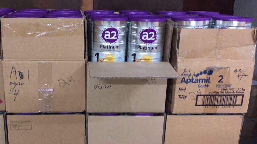 cardboard boxes full of silver baby formula tins