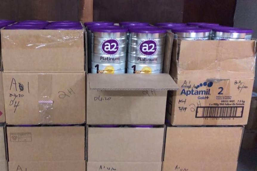cardboard boxes full of silver baby formula tins