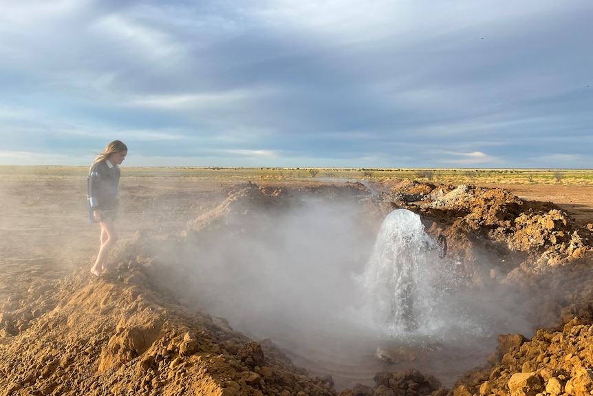 A free flowing bore with water rushing out of the new pipe