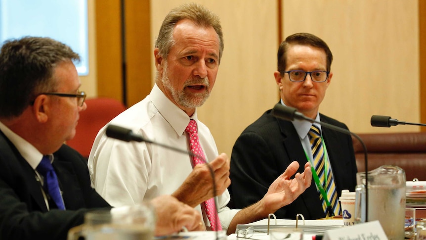 Nigel Scullion with hands spread in front of him in Senate Estimates