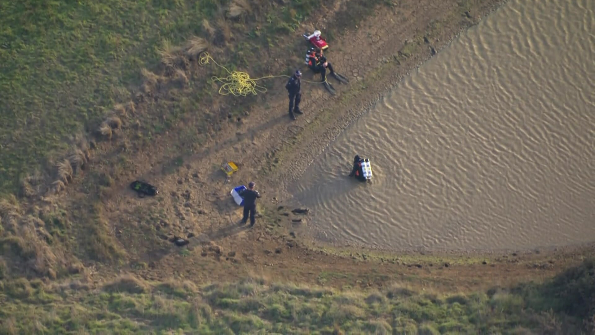 Police officers searching a dam
