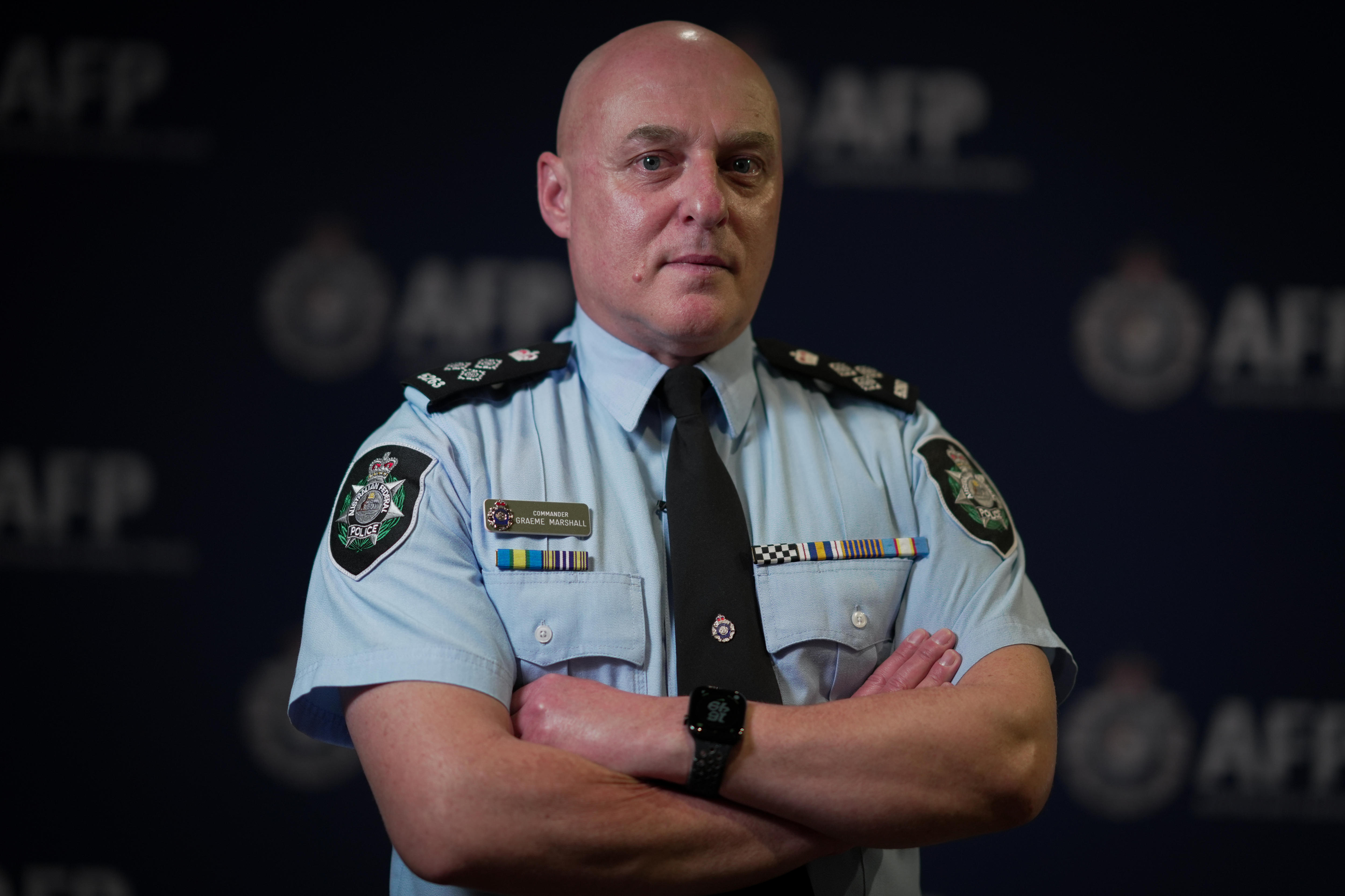 An AFP officer crosses his arms.
