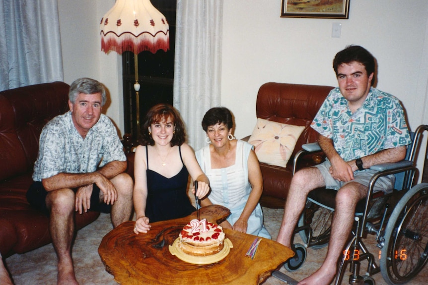 The Taylors in their lounge room celebrating Megan's 21st birthday with a cake