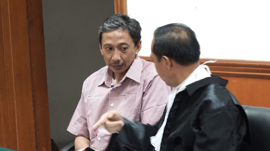 Dwi Djoko Wiwoho listens as his lawyer talks in an Indonesian court room