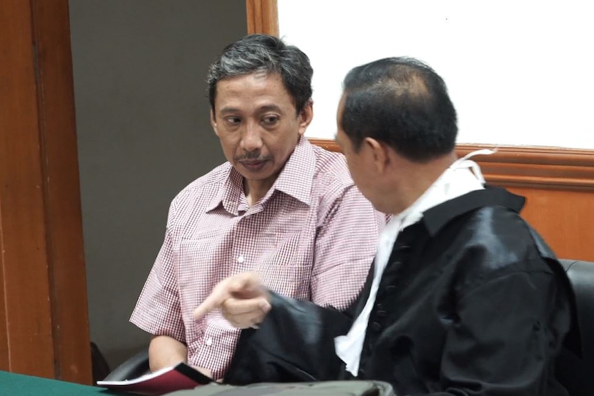 Dwi Djoko Wiwoho listens as his lawyer talks in an Indonesian court room