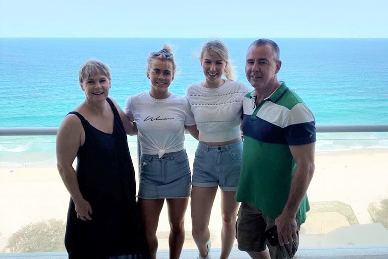Amy Rathmell with her parents and sister on a beach in Quensland.