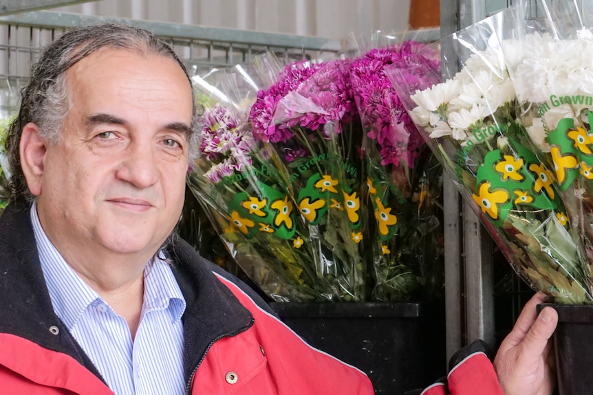 A man stands in front of flowers packaged with the new logo