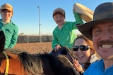 Two young children and two adults in outback Queensland smiling together 