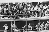 Black and white photo showcases people crowded onto a boat